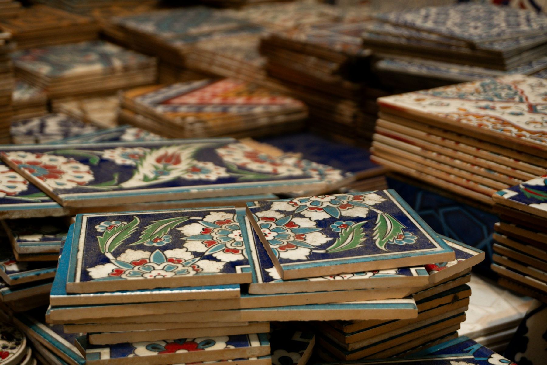 Stacks of hand-painted glazed tiles in cobalt, red and green